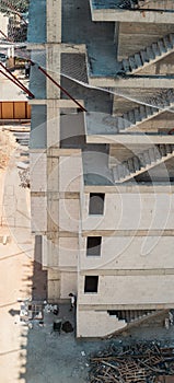 High angle view of a building under construction with unfinished concrete staircases and construction site safety net