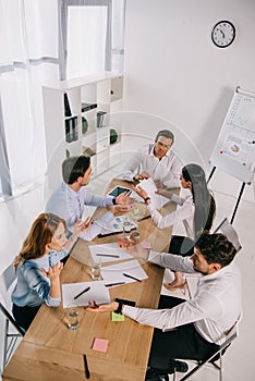 high angle view of business colleagues discussing business idea at workplace