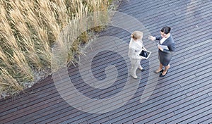 High angle view of businesswomen discussing while standing on floorboard