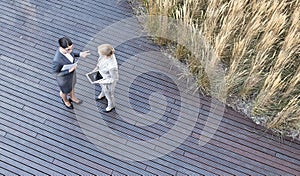 High angle view of businesswomen discussing while standing on floorboard