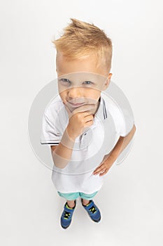 High angle view of Caucasian preschool boy isolated on white studio background. Copyspace for ad. Childhood, education