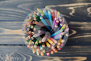 High angle view on colored pencils against wooden surface