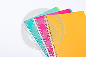 High angle view of colorful notebooks isolated on white.
