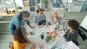 High angle view of confident women making feminists banners and discussing ideas in office