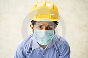 High angle view of Construction worker in medical mask looking up in confident - concept of business, industry reopen