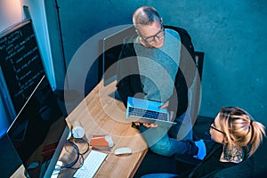 high angle view of couple of hackers working on malware together