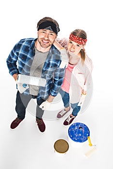 high angle view of couple in headbands and protective gloves standing with paint roller