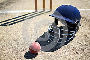 High angle view of cricket ball with helmet on pitch