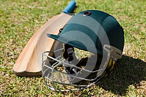 High angle view of cricket helmet and bat on field