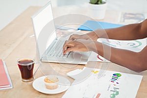 High angle view of cropped hands working on laptop