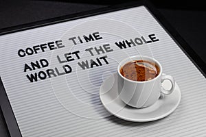 High angle view on cup of coffee and a letter board with inscription.