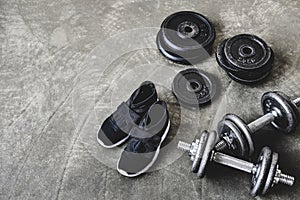 high angle view of dumbbells with weight plates and sneakers