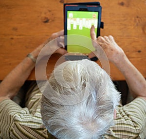 High Angle View of an Elderly Woman Playing Solitaire on a Table