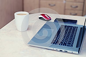 High angle view of an empty workplace. Laptop with coffee cup home office. Close up view of a work desk interior with a laptop