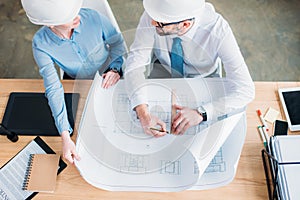 high angle view of experienced architects working with building plan