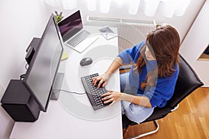 Female programmer coding while working in home office