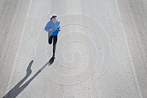 High angle view of female runner jogging on road city.