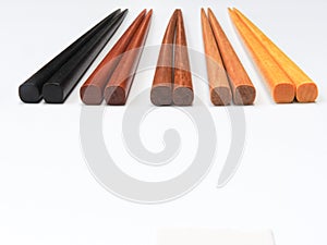 High angle view of five pairs wooden chopsticks are arranged isolated on white background.