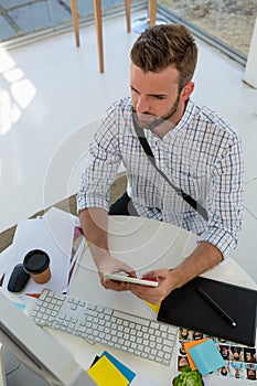 High angle view of graphic designer using tablet computer at desk