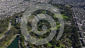 High angle view of green public park for relaxing. Tilt up reveal panoramic view of metropolis. San Francisco