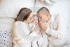 High angle view of happy family with newborn baby lying on bed at home.