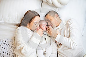 High angle view of happy family with newborn baby lying on bed at home.