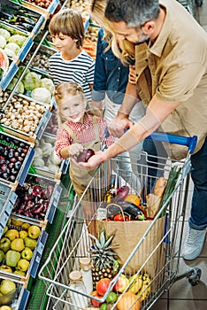 high angle view of happy family with trolley shopping together