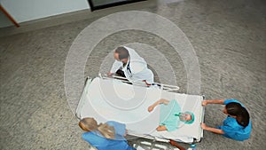 High angle view of a hospital team wheeling a patient on a bed