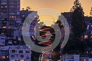 High angle view of illuminated homes on Lombard Street in San Francisco, California at sunset with car light trails