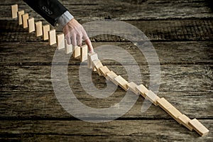 High angle view image of a businessman stopping domino effect