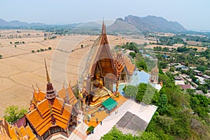 High angle view of a large Buddha image Among the rice fields and behind is a mountain with Buddhists paying respect for blessing