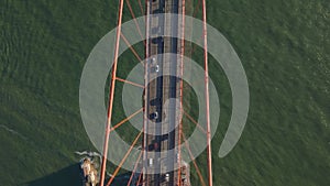 High angle view of large suspension bridge over rippled water at golden hour. Vehicles driving on Golden Gate Bridge