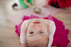 High angle view of little girl with down syndrome at ballet class in dance studio. Concept of integration and education