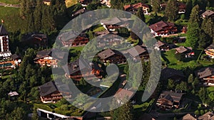 High angle view of luxury buildings in Swiss chalet style with well maintained surroundings at golden hour. Alpine