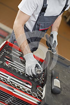 High angle view of male mechanic arranging tools in drawer at car repair shop