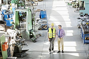 High angle view of male supervisor and manual worker having discussion in metal industry