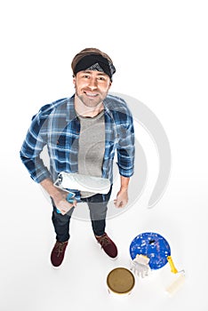 high angle view of man in headband standing with paint roller