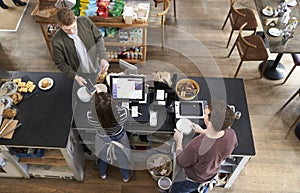 High angle view of man paying over counter at a coffee shop