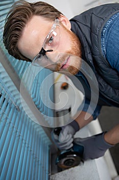 high-angle view man using angle grinder