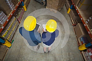 High angle view of managers with hard hat holding tablet and clipboard