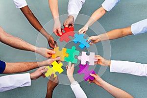 High Angle View Of Medical Team Solving Jigsaw Puzzle