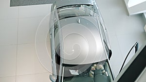 High angle view of men sales manager and customer sitting in car in dealership