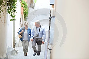 High angle view of middle-aged couple holding hands while climbing steps outdoors