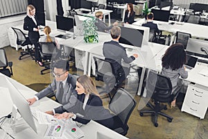 High angle view of multiethnic businesspeople working with papers and desktop computers