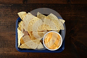 High angle view nacho chips with cheese in plastic container