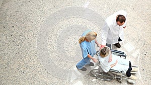 High angle view of a nurse wheeling a patient in a wheelchair