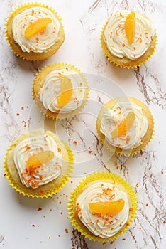 High angle view orange vanilla cream cupcakes