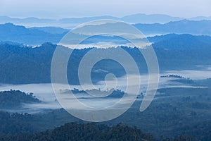 High angle view over tropical mountains with white fog in early morning