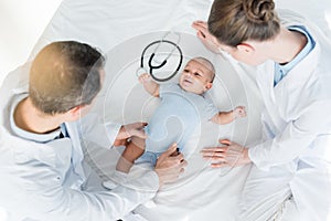 high angle view of pediatricians playing with little baby photo