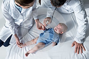 high angle view of pediatricians trying to check breath of photo